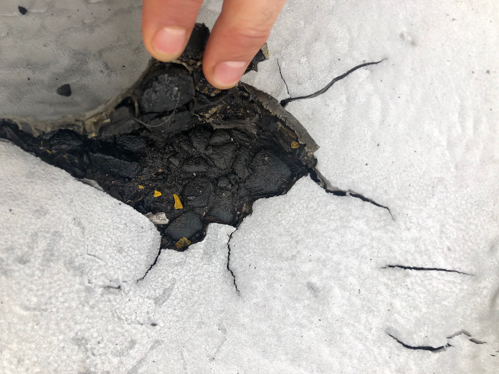 Primed asphalt substrate receiving a protective coating