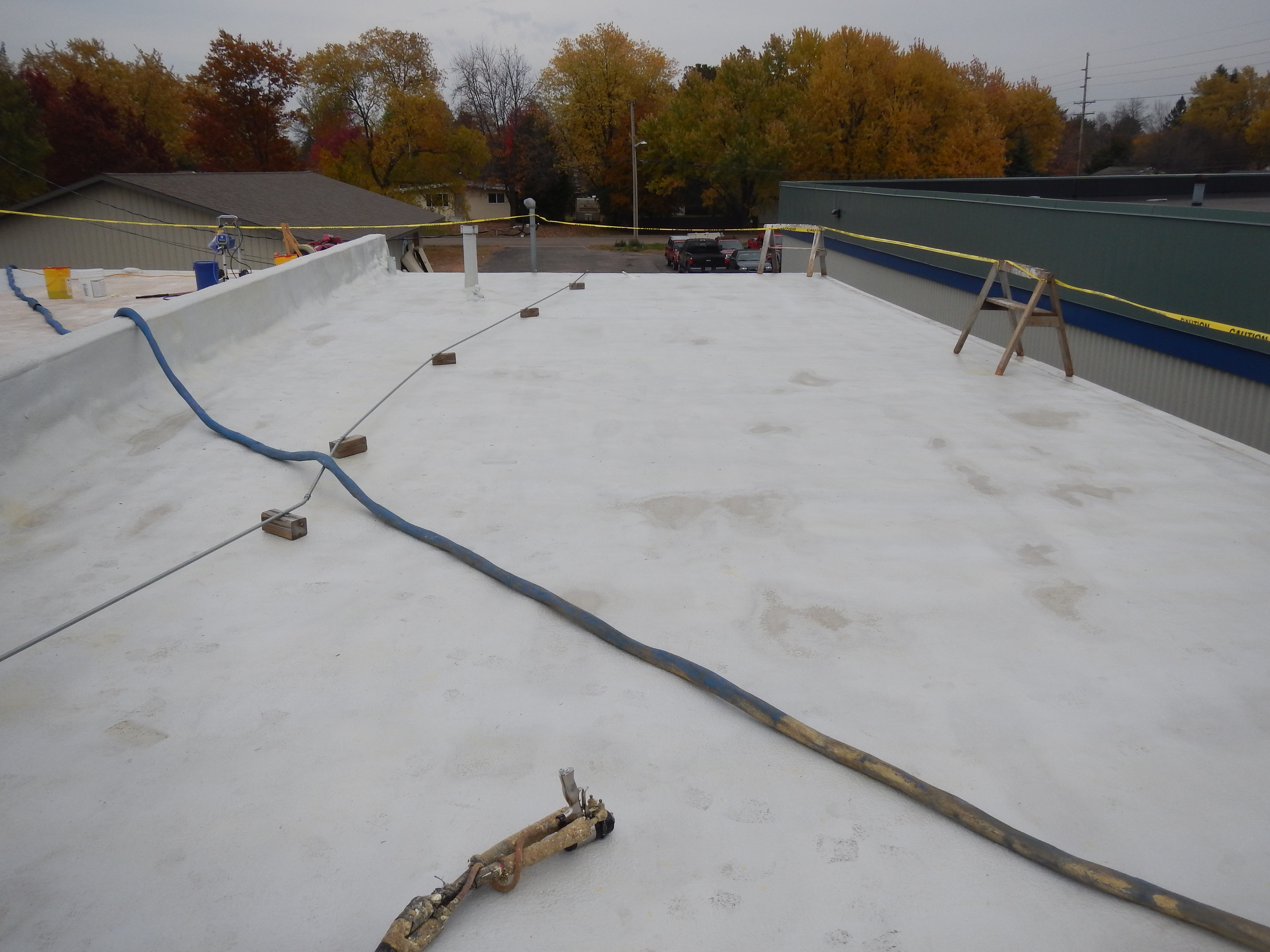 Roof restoration over existing single-ply membrane using primer and polyurea