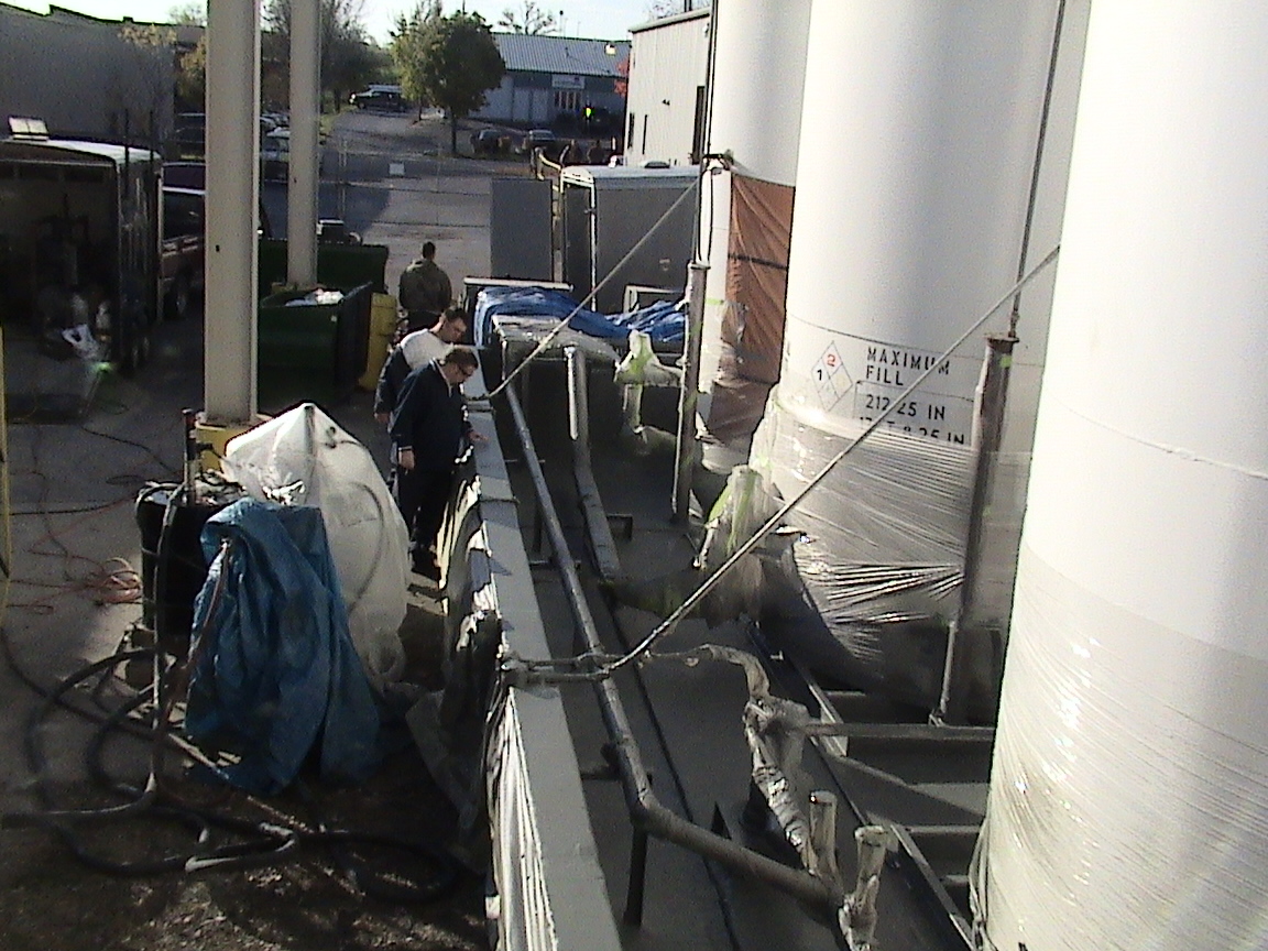 Single-ply roof being prepared and primed for coating restoration